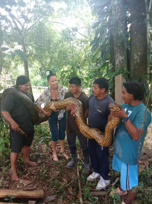 Familia Baihuaeri sosteniendo una anaconda